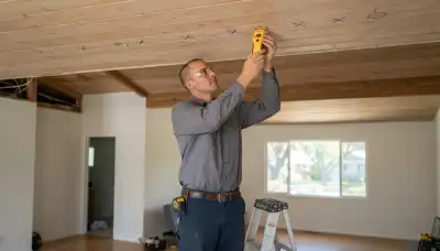 Santa Rosa, CA electrician using a stud finder to mark ceiling joists for recessed lighting installation